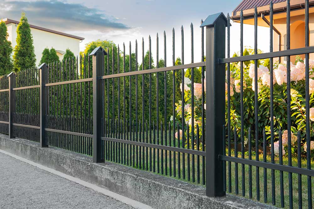 Beautiful black iron fence near pathway outdoors