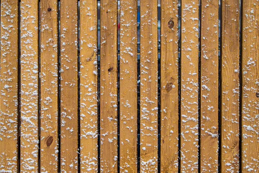 Wooden fence in the snow background